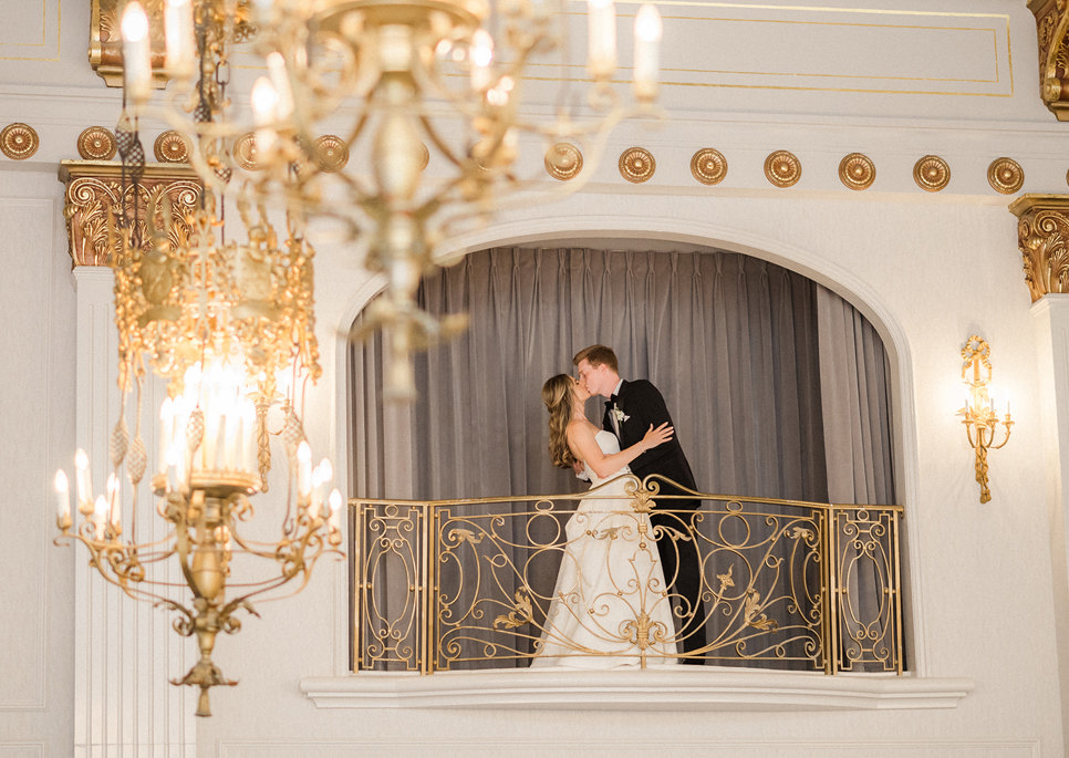 Married couple kissing on balcony