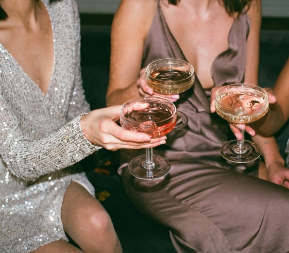 Women giving a cheers with close up of cocktails