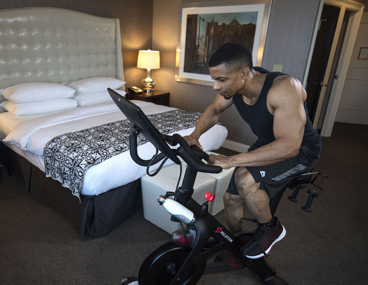 Man on Peloton in hotel room